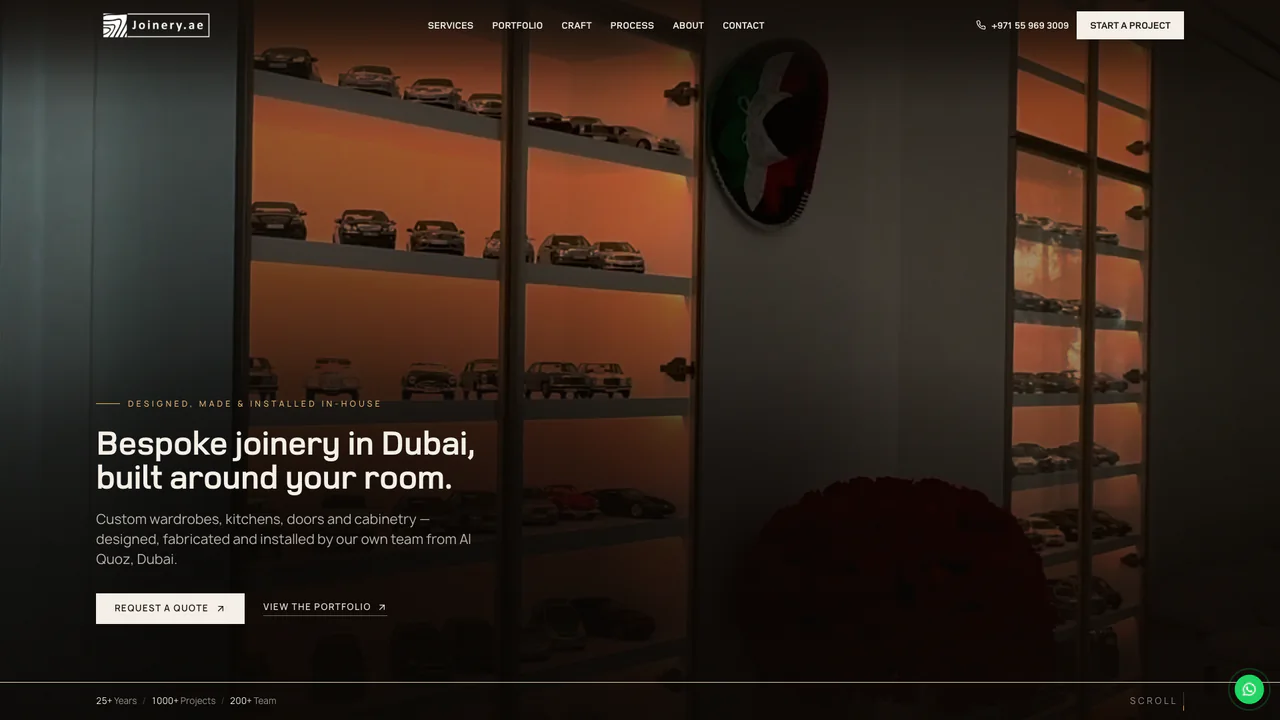 The Joinery.ae homepage: “Bespoke joinery in Dubai, built around your room.” over a dim photograph of a backlit glass display cabinet filled with model cars, with Request a Quote and View the Portfolio buttons and a strip reading 25+ years, 1000+ projects and a 200+ team.